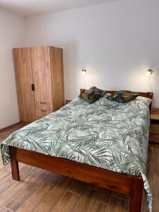 een slaapkamer met een bed en een houten kast bij Dom Nad Jeziorem Trzy Tonie 