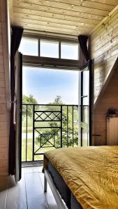 a bedroom with a bed and a large window at Kleine Huisje in Ruinerwold