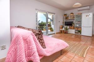 a bedroom with a pink blanket on a bed at House Spirit of the sea in Ražanj