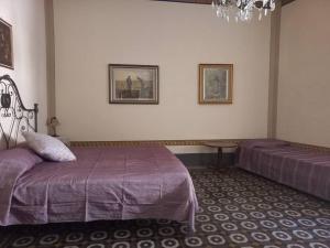 a bedroom with two beds and a chandelier at La casa Maestri a Cetona in Cetona