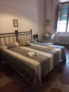 a bedroom with two beds and a table and a window at La casa Maestri a Cetona in Cetona