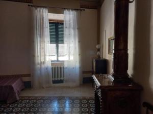 a bedroom with a window and a bed and a television at La casa Maestri a Cetona in Cetona