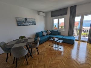 a living room with a blue couch and a table at Apartment Arya in Crikvenica