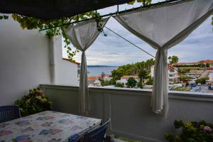 uma varanda com uma mesa e vista para o oceano em Apartment in Banjol/Insel Rab 26609 em Banjol