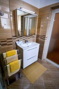 uma casa de banho com um lavatório e um espelho em Apartment in Banjol/Insel Rab 26609 em Banjol