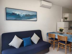 sala de estar con sofá azul y mesa en Des Artistes Lloret de Mar en Lloret de Mar