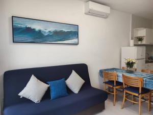 a living room with a blue couch and a table at Des Artistes Lloret de Mar in Lloret de Mar