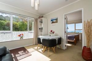 1 dormitorio y sala de estar con mesa y sillas. en Harbour View Guesthouse en Auckland