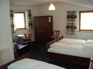 1 Schlafzimmer mit 2 Betten, einem Tisch und Stühlen in der Unterkunft Hotel-Garni Kaiserhof in Rauris