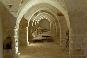 a room with an archway with a couch and tables at Masseria Rescio in Avetrana
