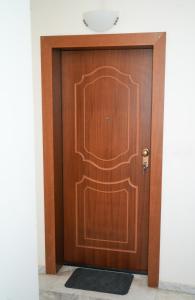 een houten deur in een kamer met een zwart tapijt bij Stefanos apartment in Nafplio