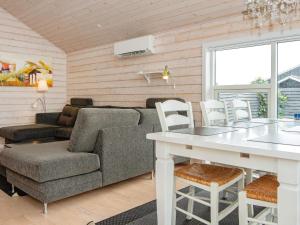 ein Wohnzimmer mit einem Sofa und einem Tisch in der Unterkunft Holiday Home As Hedegård II in Sønderby