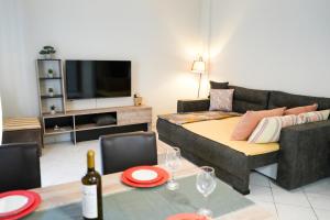 een woonkamer met een bank en een tafel met wijnglazen bij Stefanos apartment in Nafplio