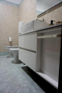 bagno bianco con lavandino e servizi igienici di A CASA CAVOUR Apartment RIMINI CENTER Teatro Galli a Rimini