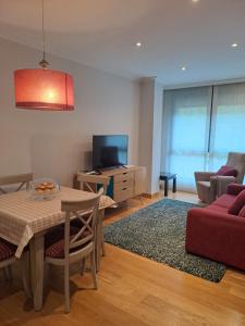a living room with a table and a red couch at Apartamento en el centro con garaje directo. in Bilbao