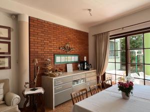 a dining room with a table and a brick wall at Dietrichsteinerhof Apartments & Rooms in Faak am See