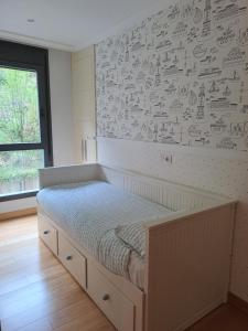 Un dormitorio con una cama y una pared con dibujos. en Apartamento en el centro con garaje directo., en Bilbao