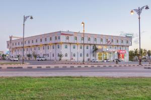 a large white building on the side of a street at Al Jabal Hotel in Salalah