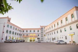 duży budynek z samochodami zaparkowanymi na parkingu w obiekcie Al Jabal Hotel w mieście Salala