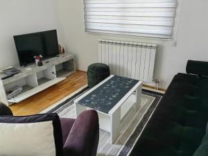 a living room with a couch and a table at Apartment Lukavica in Lukavica