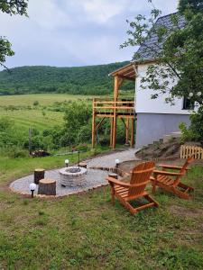 twee banken en een vuurplaats in een tuin bij Eged Lodge in Eger