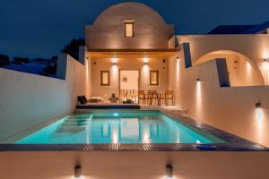 a villa with a swimming pool at night at Living Moments in Fira