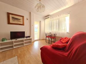 sala de estar con sofá rojo y TV en Apartman Tea, en Novi Vinodolski