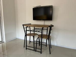 a table with two chairs and a tv on a wall at Apartment Monaliza in Pirot