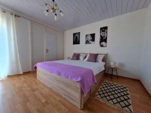 1 dormitorio con 1 cama grande con manta morada en Apartman Tea, en Novi Vinodolski