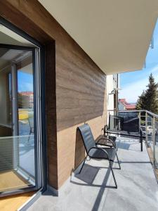 a patio with a chair and a television on a balcony at WIŚLANY PORT WILLA in Krynica Morska