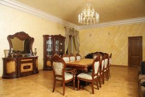 ein Esszimmer mit einem Tisch, Stühlen und einem Kronleuchter in der Unterkunft Eriks guest house in Goris
