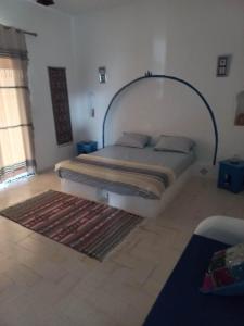 um quarto com uma cama e um tapete no chão em villa la rose des sables em Midoun