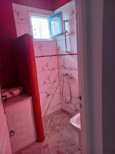 a pink bathroom with a sink and a toilet at villa la rose des sables in Midoun