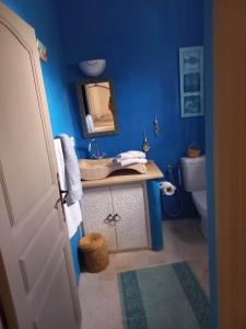 Baño azul con lavabo y aseo en villa la rose des sables, en Midoun