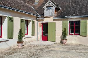 une maison avec des portes vertes et rouges et deux plantes dans l'établissement Le P'tit Beine, à Mont-près-Chambord