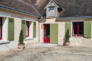 a house with green and red doors and two plants at Le P'tit Beine in Mont-près-Chambord