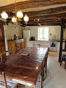 une cuisine avec une grande table en bois et des chaises dans l'établissement Le P'tit Beine, à Mont-près-Chambord