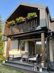 a dog sitting in front of a house with a balcony at UGRAD family in Slavske