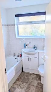 y baño con lavabo, bañera y aseo. en Comfortable bungalow near Widemouth Bay beach, en Poundstock