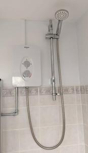 y baño con ducha con cabezal de ducha. en Comfortable bungalow near Widemouth Bay beach, en Poundstock