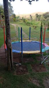 a trampoline in a park next to a tree at Sítio Alazão in Moeda