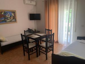 Habitación con mesa, sillas y cama en Julia Apartments en Vlorë