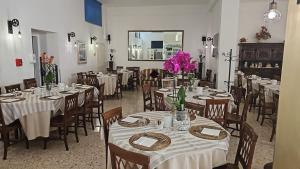 una sala da pranzo con tavoli e sedie con fiori rosa di Hotel Il Gioiello a Sabaudia