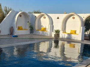 une maison avec une piscine en face de celle-ci dans l'établissement villa la rose des sables, à Midoun