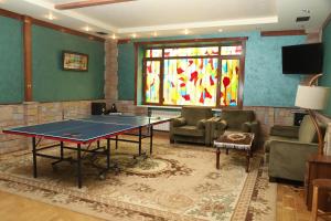 a room with a ping pong table and a stained glass window at Eriks guest house in Goris