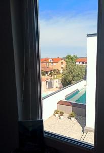 a view of a swimming pool from a window at Abelia Pool View Studio in Pula