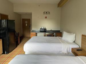 a hotel room with a large bed and a kitchen at AIRPORT LODGING Pittsburgh Airport in Coraopolis