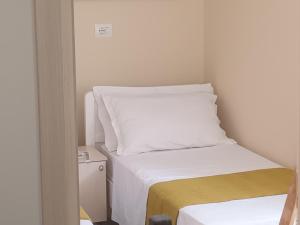 a small room with two beds with white sheets at holiday house in Durrës