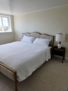 a bedroom with a large white bed with a window at Island View House BnB Self Check-In in Portland