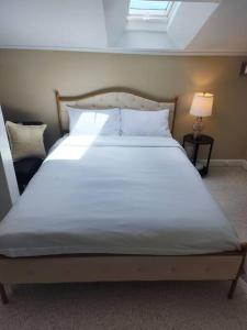 a large white bed in a bedroom with a window at Island View House BnB Self Check-In in Portland